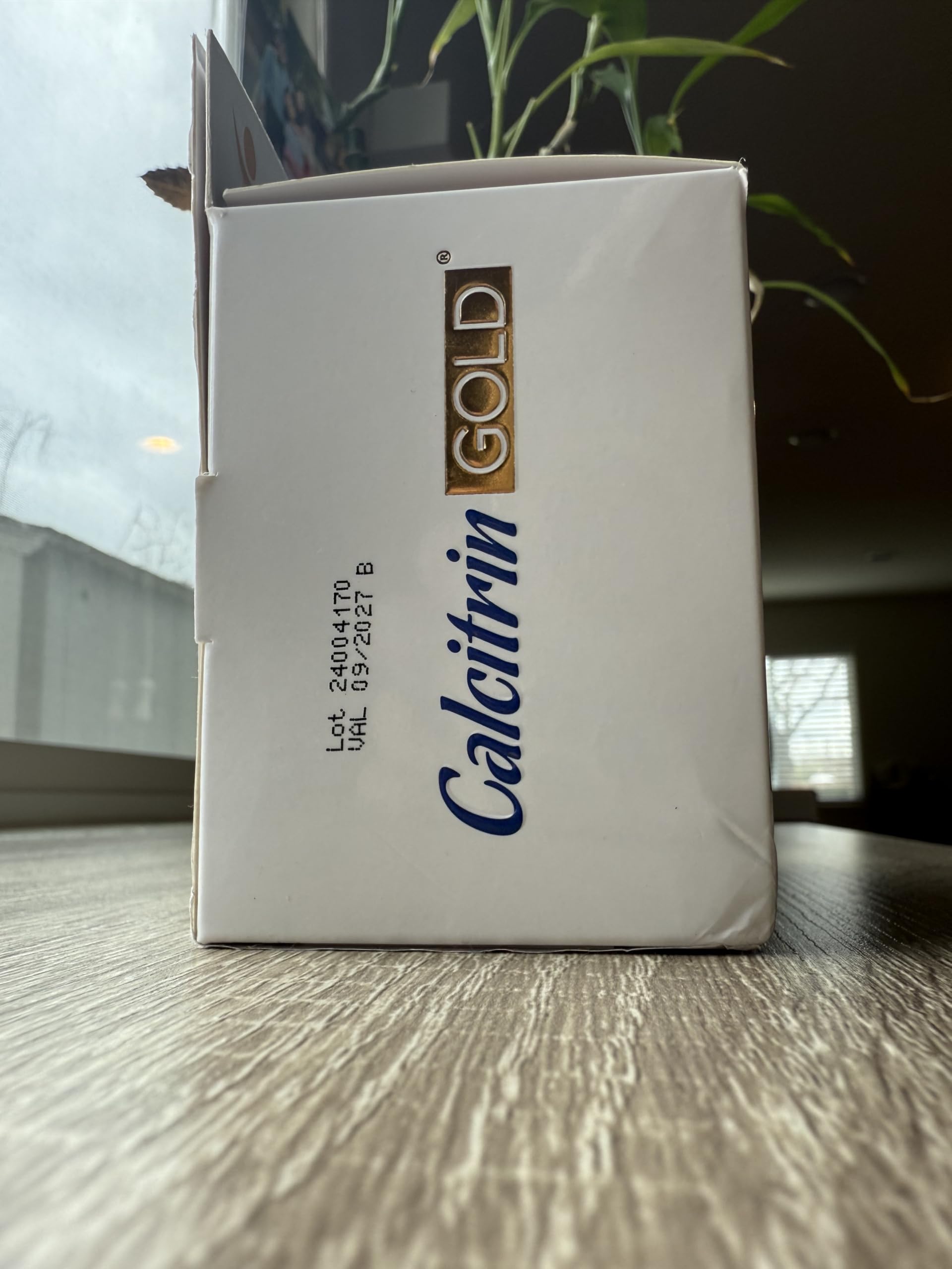 Soy Sano Calcitrin Gold packaging beside a glass of water for dosing.