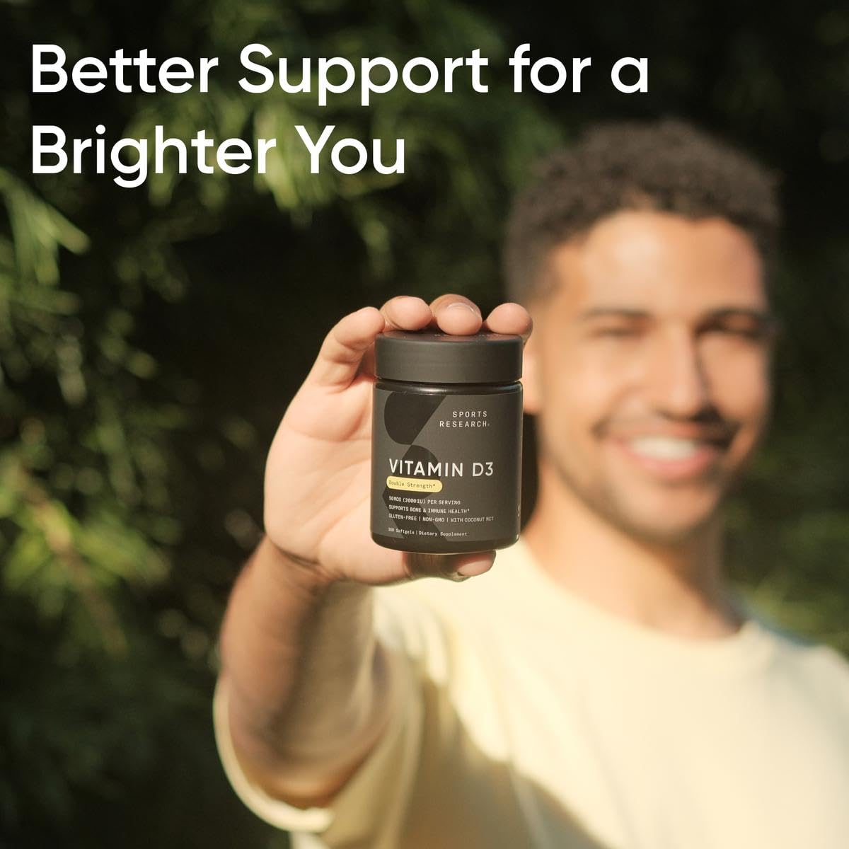 Sports Research Vitamin D3 bottle next to a glass of water for absorption with fat.