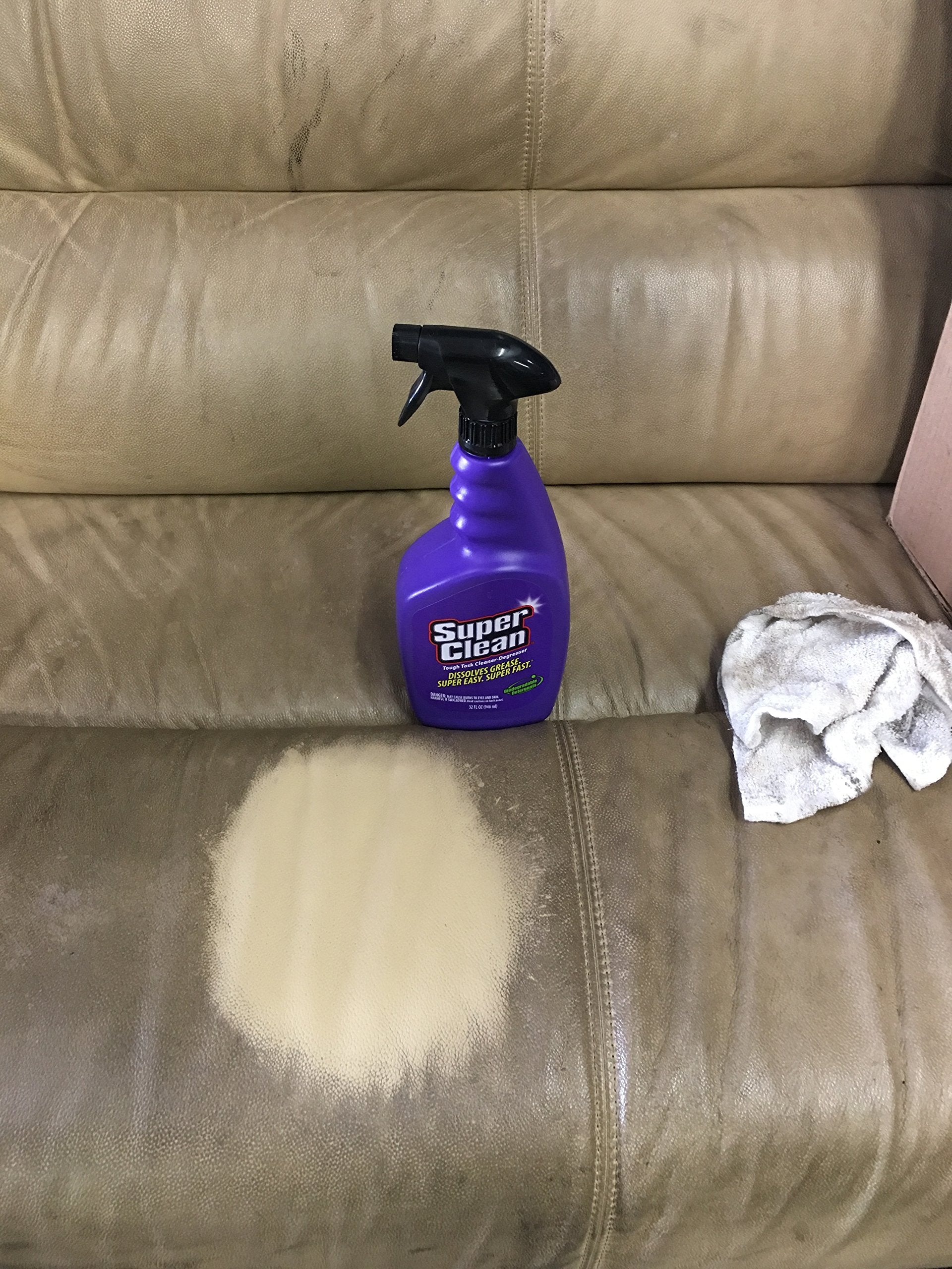 Purple cleaner being sprayed on engine grime to dissolve grease