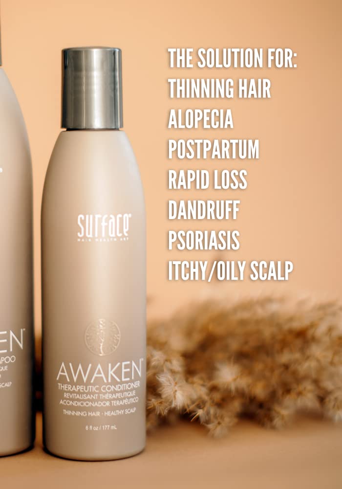Hands applying Surface Awaken conditioner for scalp care.