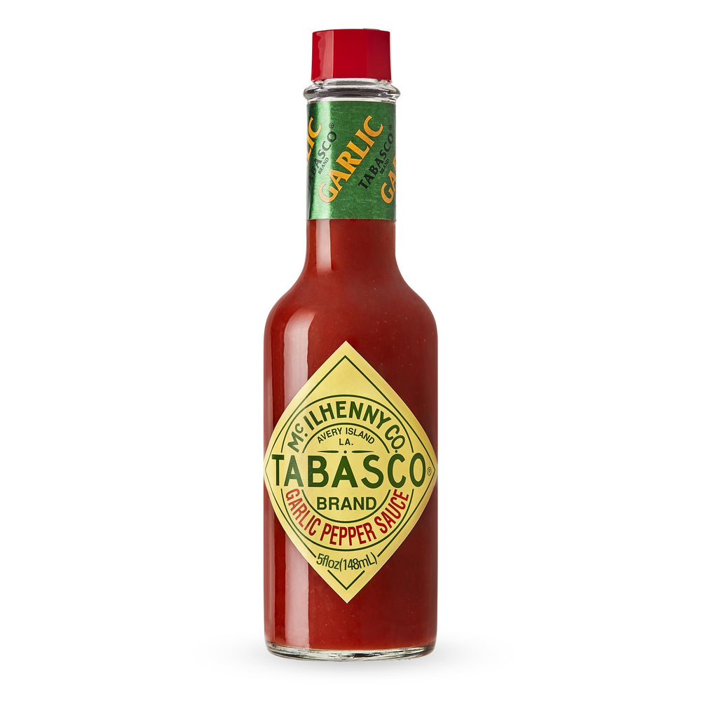 TABASCO Cayenne Garlic Pepper Sauce bottle on counter adds mild heat to meals.