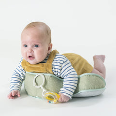 Baby in tummy position on Taf Toys support during gentle play
