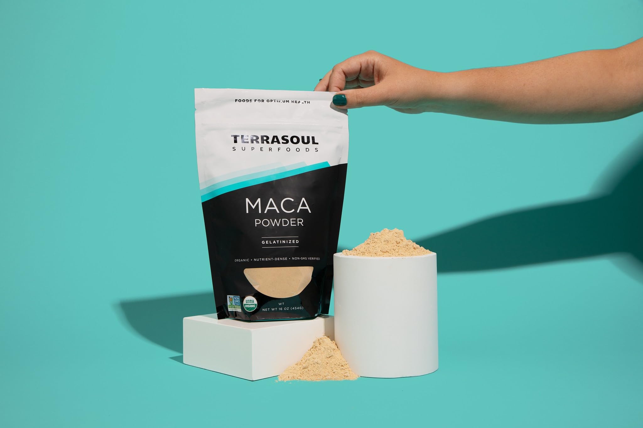 Terrasoul maca powder pour action over a breakfast bowl.