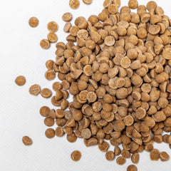 Close-up texture of mini cinnamon drops showing smooth chips and cinnamon aroma.