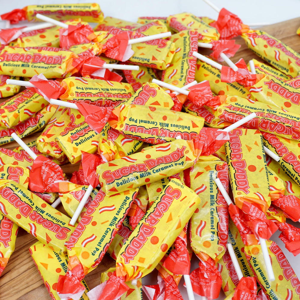 Party display featuring Sugar Daddy lollipops invites sharing.