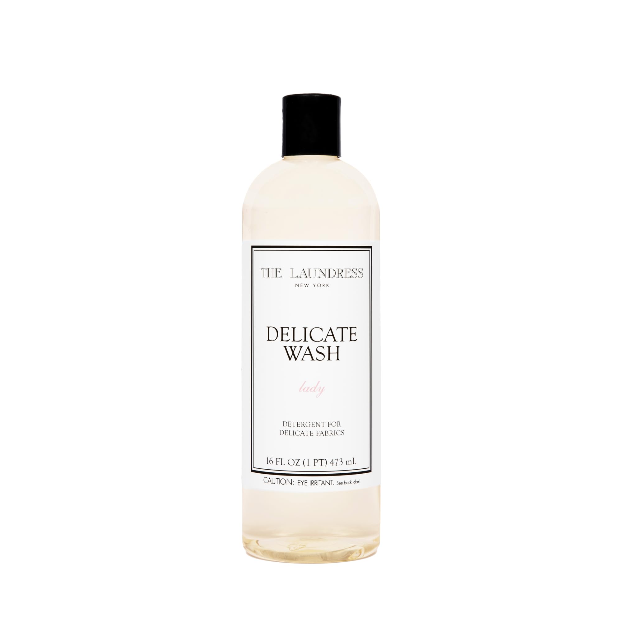 The Laundress Delicate Wash bottle pour demonstrates gentle, controlled dosing for delicate fabrics.