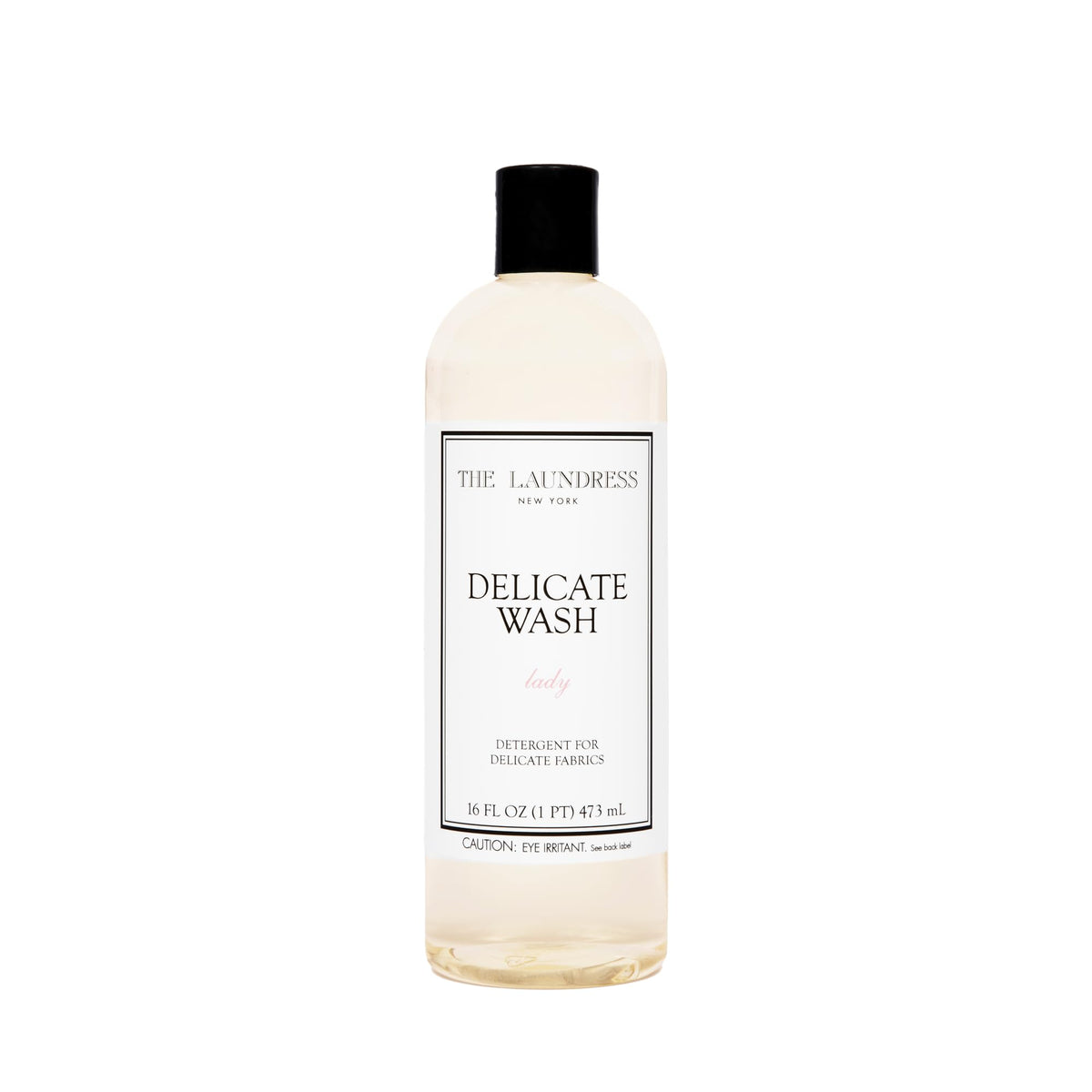 The Laundress Delicate Wash bottle pour demonstrates gentle, controlled dosing for delicate fabrics.