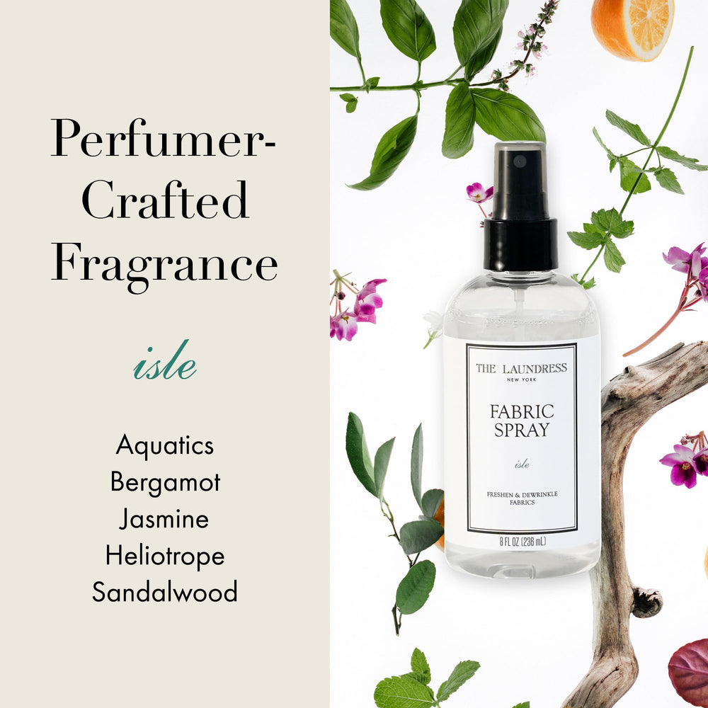 The Laundress Isle linen spray misting on clean sheets for fresh aroma.