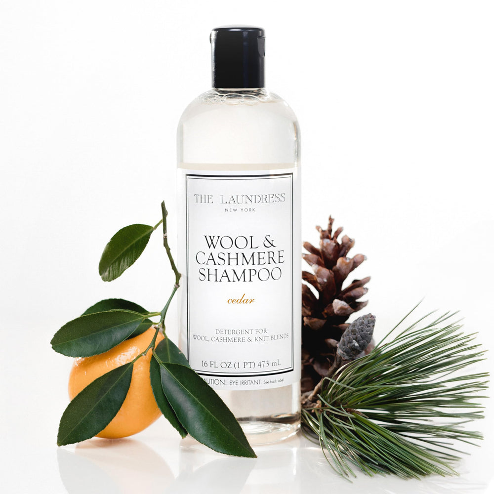 The Laundress Wool & Cashmere Shampoo bottle pour demonstrates gentle cleaning for delicate knits.