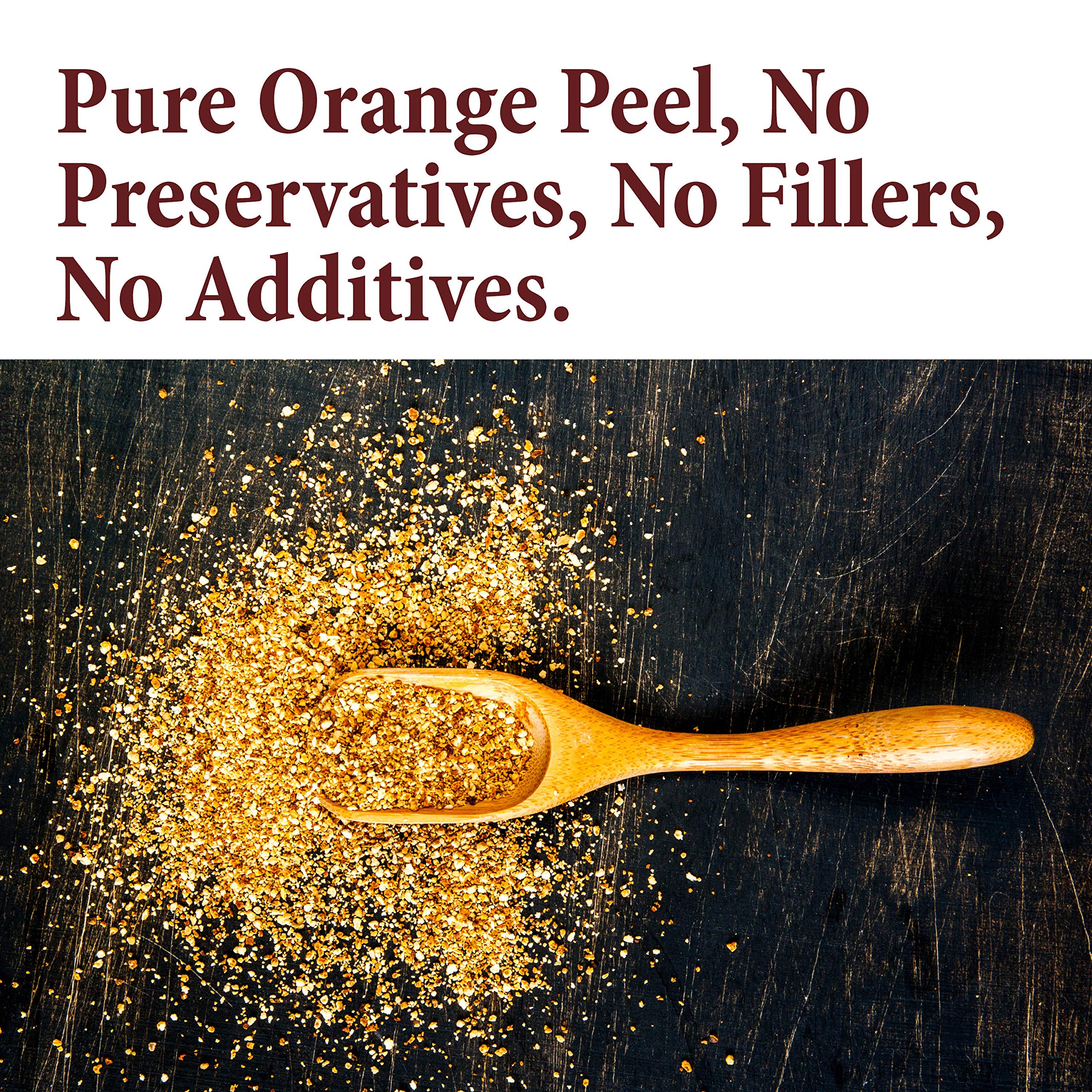 The Spice Way orange peel granules on a spoon release citrus aroma for tea and meat dishes.