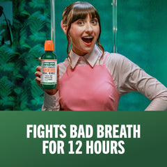 Pouring TheraBreath mouthwash to measure the 2 teaspoons dose.