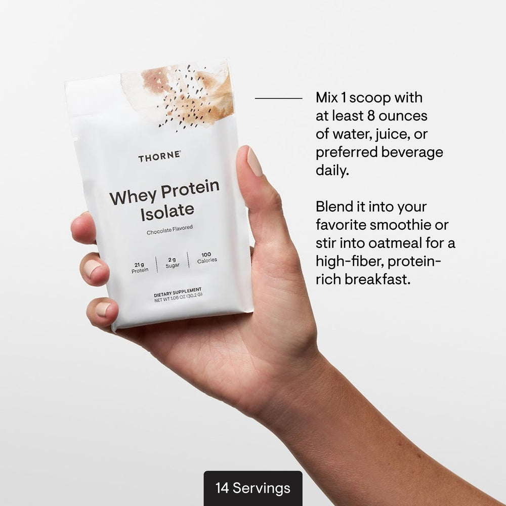 THORNE chocolate whey protein bottle with a glass of shake on a clean setup.