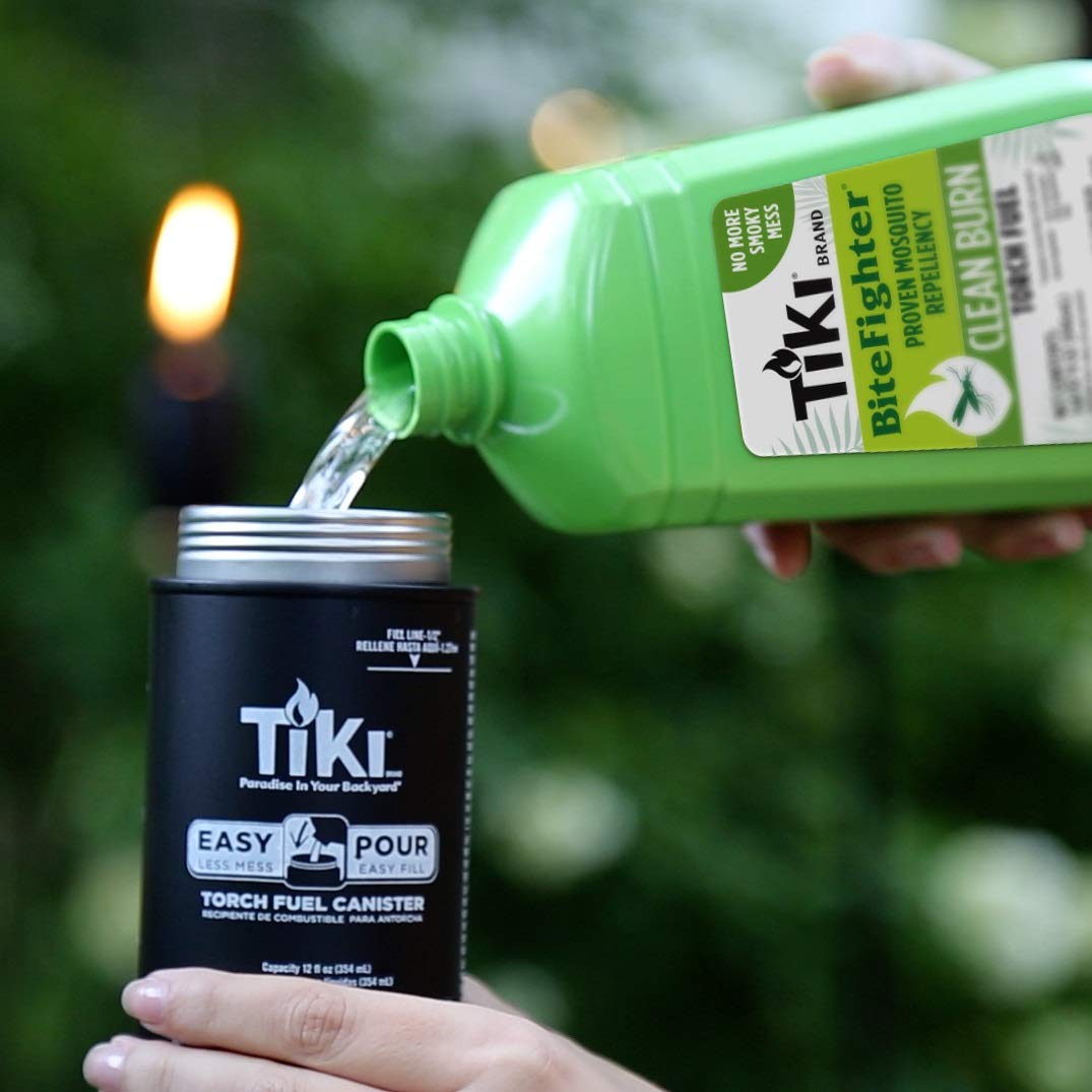TIKI Clean Burn fuel in use with outdoor torch at twilight, creating a warm glow.