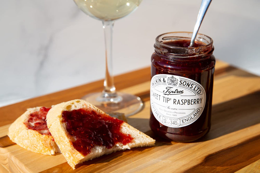 Tiptree Raspberry Preserve close-up on a spoon, glossy texture ideal for pastries.