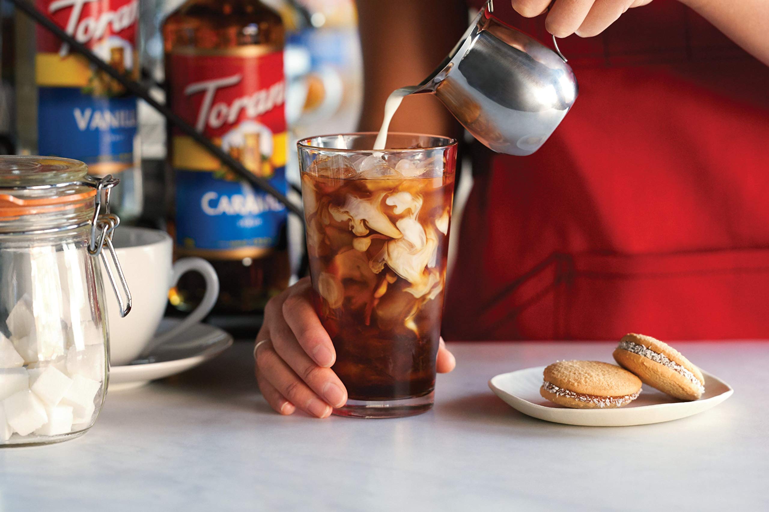 Torani Sugar Free Vanilla bottle next to a cup of tea in a mug.