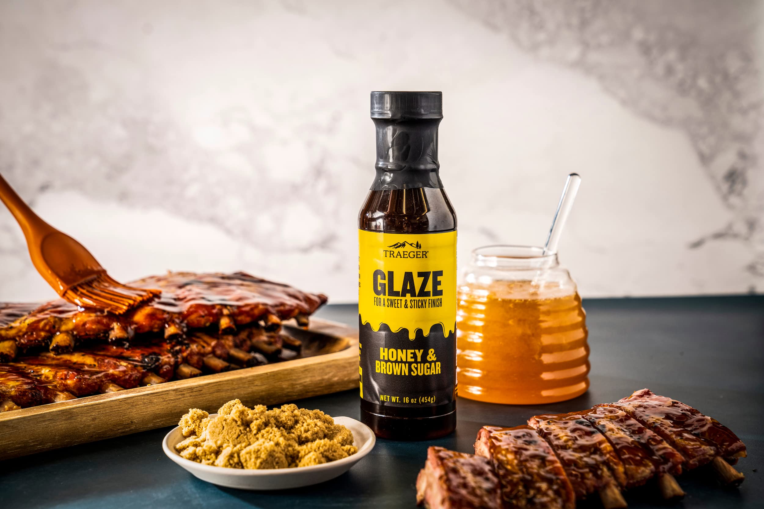 Pouring Traeger Honey & Brown Sugar Glaze over pork to caramelize.
