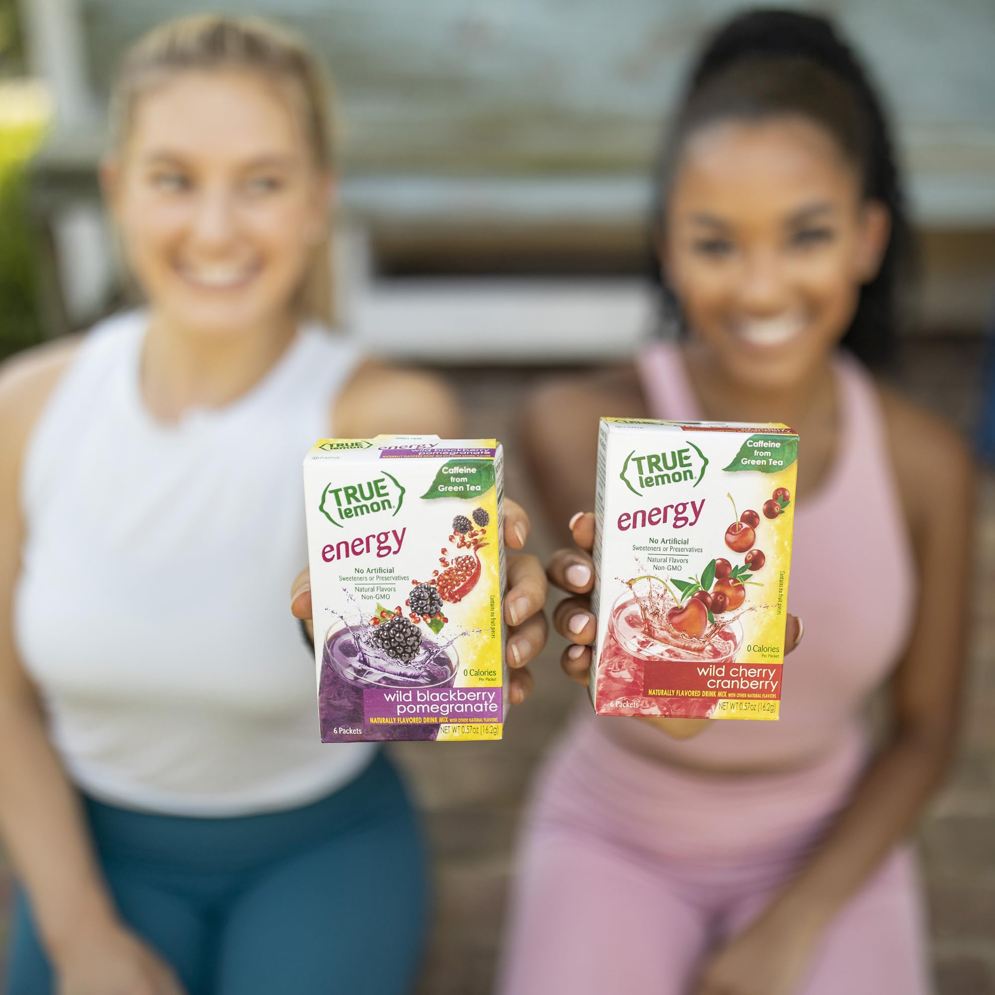 Glass with prepared True Lemon Energy Blackberry Pomegranate, vibrant purple-orange hue.