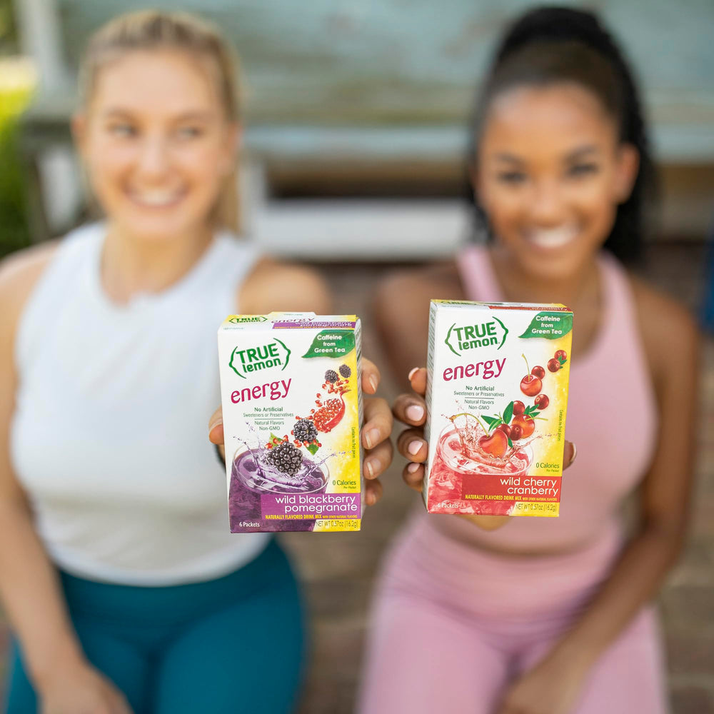 Glass with prepared True Lemon Energy Blackberry Pomegranate, vibrant purple-orange hue.