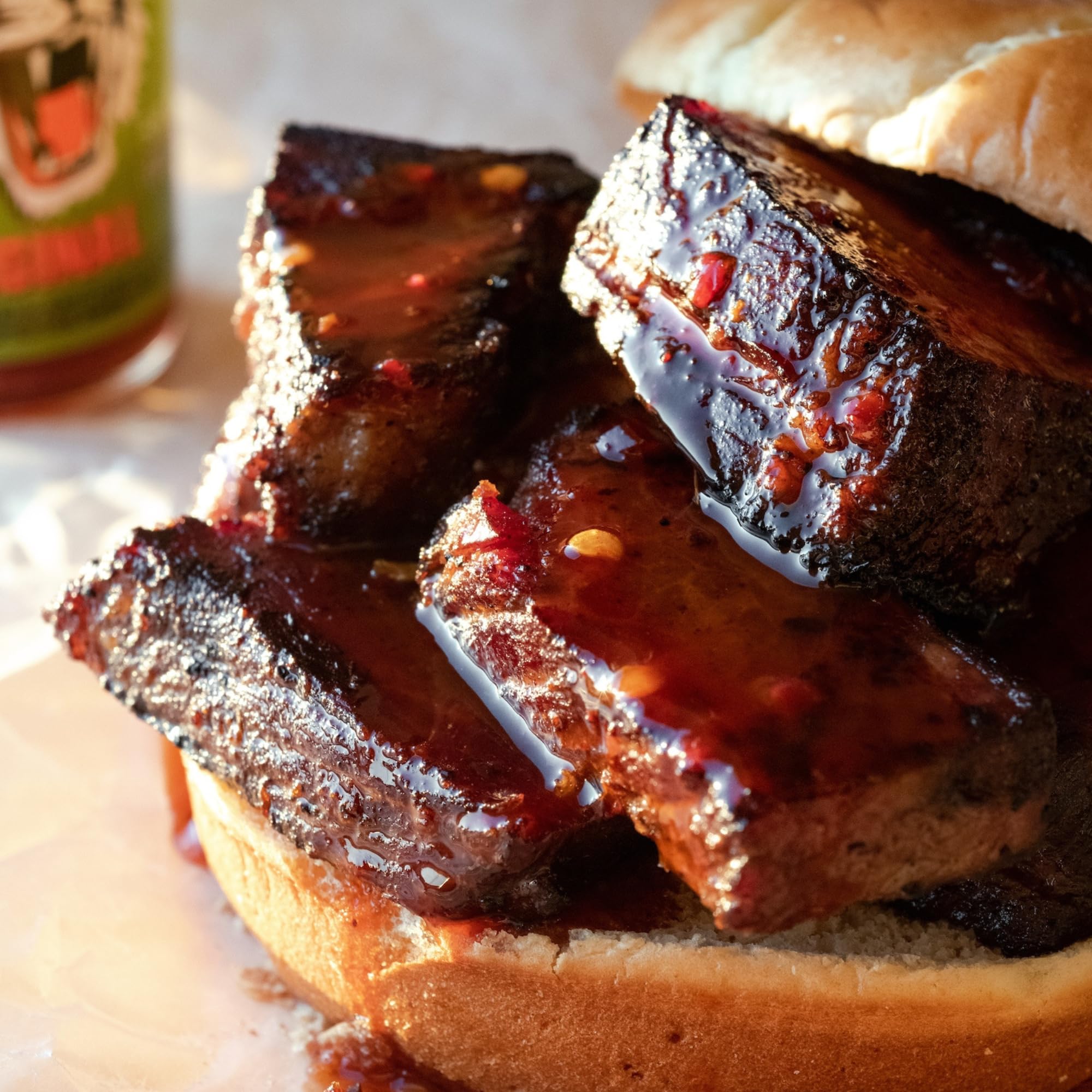 Pouring Tiger Sauce Original over grilled meats for a savory finish