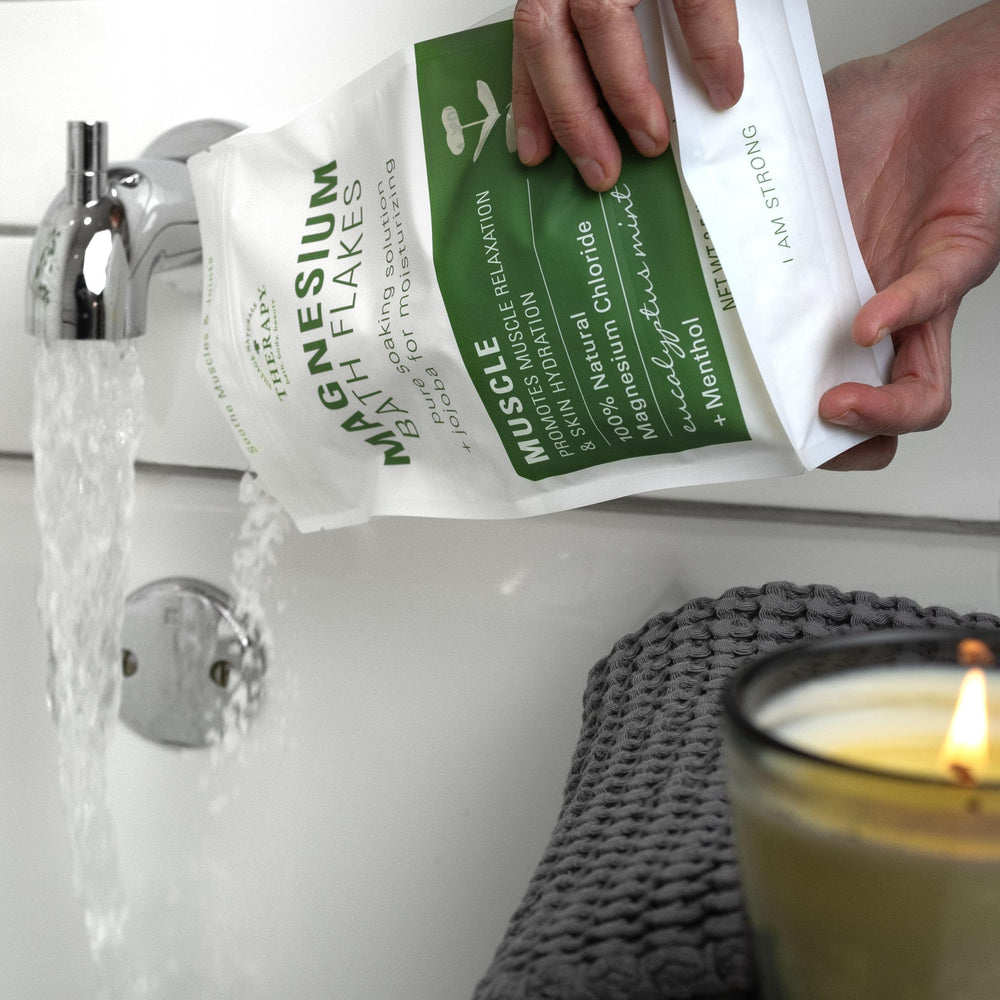 Village Naturals Therapy Muscle Magnesium Bath Flakes in a relaxing bath scene.