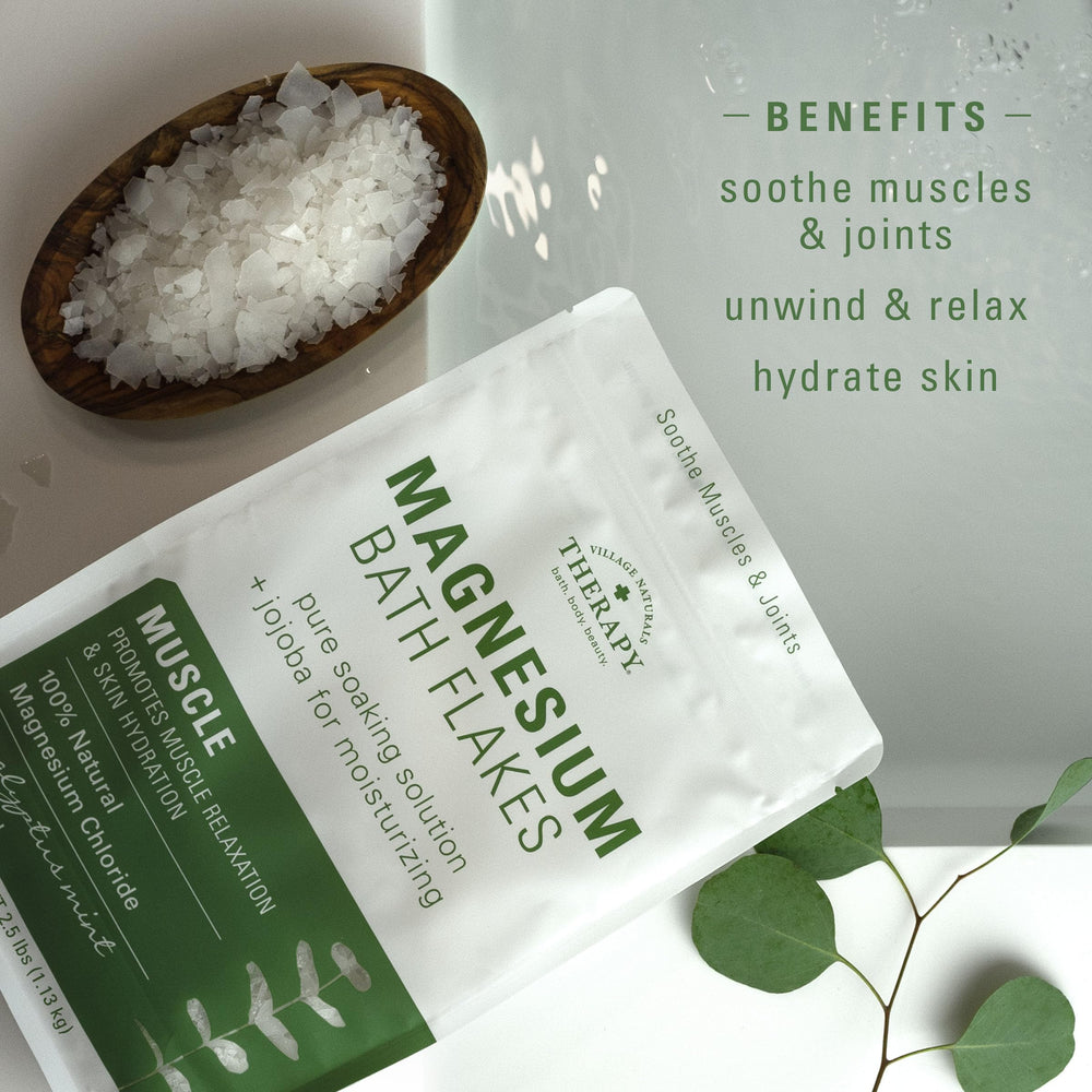 Village Naturals Therapy Muscle Magnesium Bath Flakes dissolving in tub for fast-acting soak.