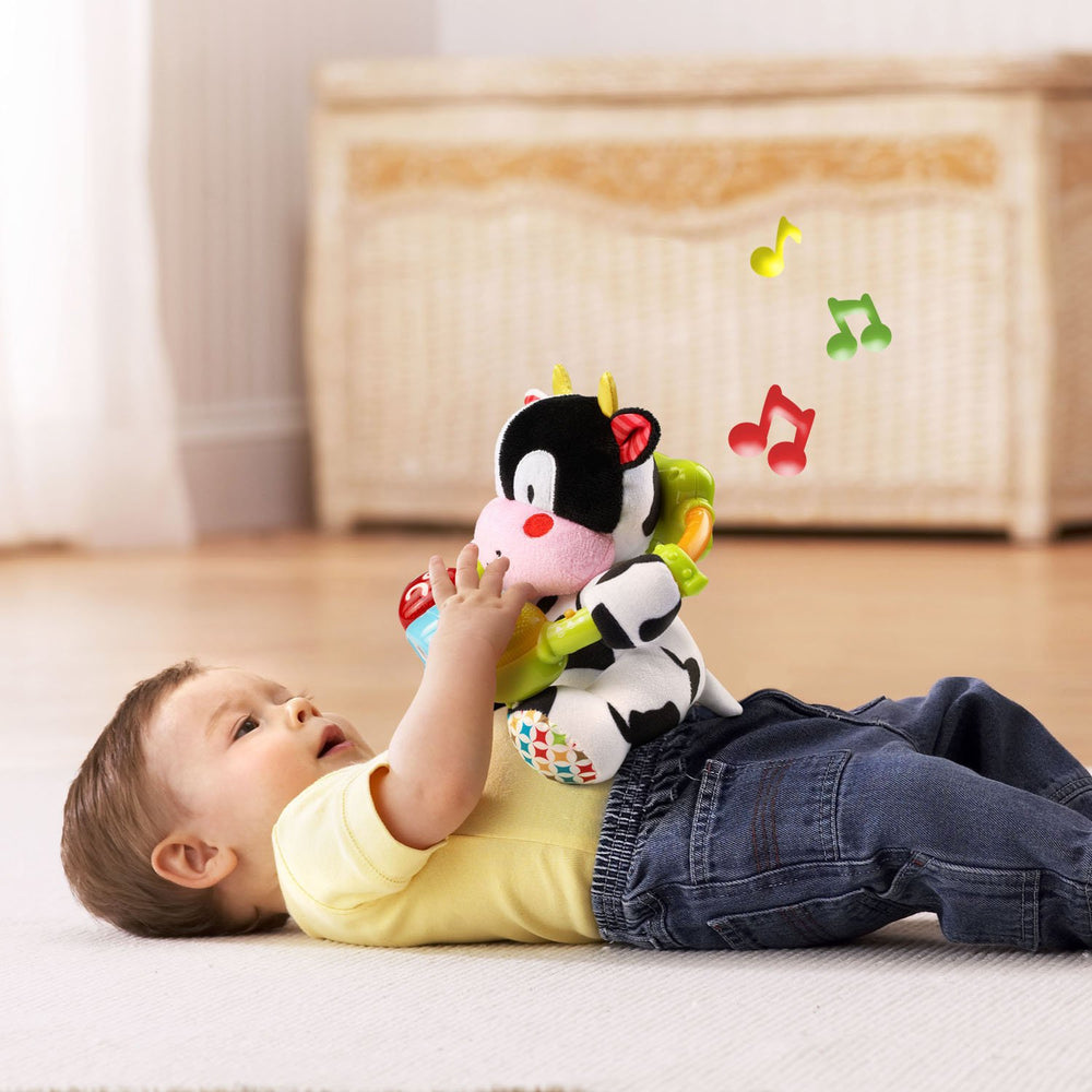 Soft textured plush cow encouraging tactile exploration.