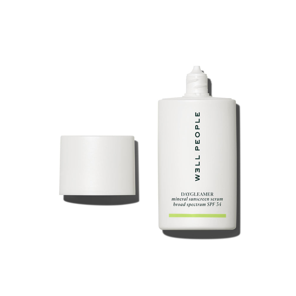 Well People Daygleamer bottle closeup showing mineral sunscreen serum for radiant, protected skin.