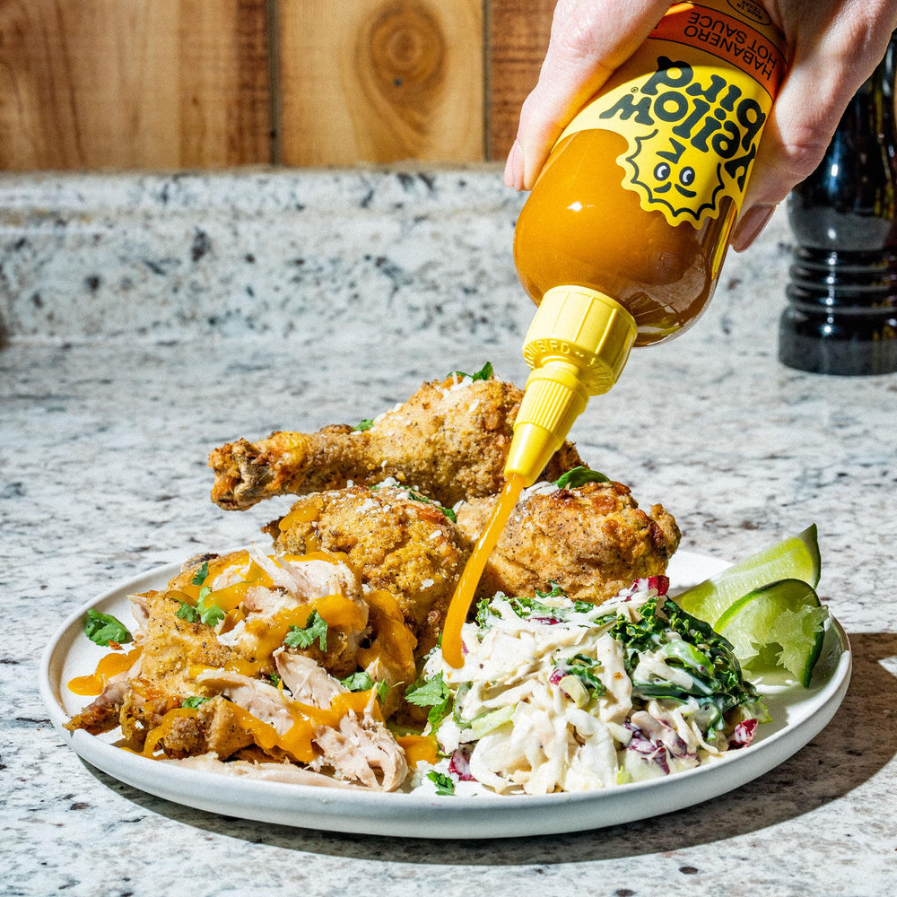 Yellowbird Classic label close-up reveals carrots, garlic, and tangerines for vibrant flavor.