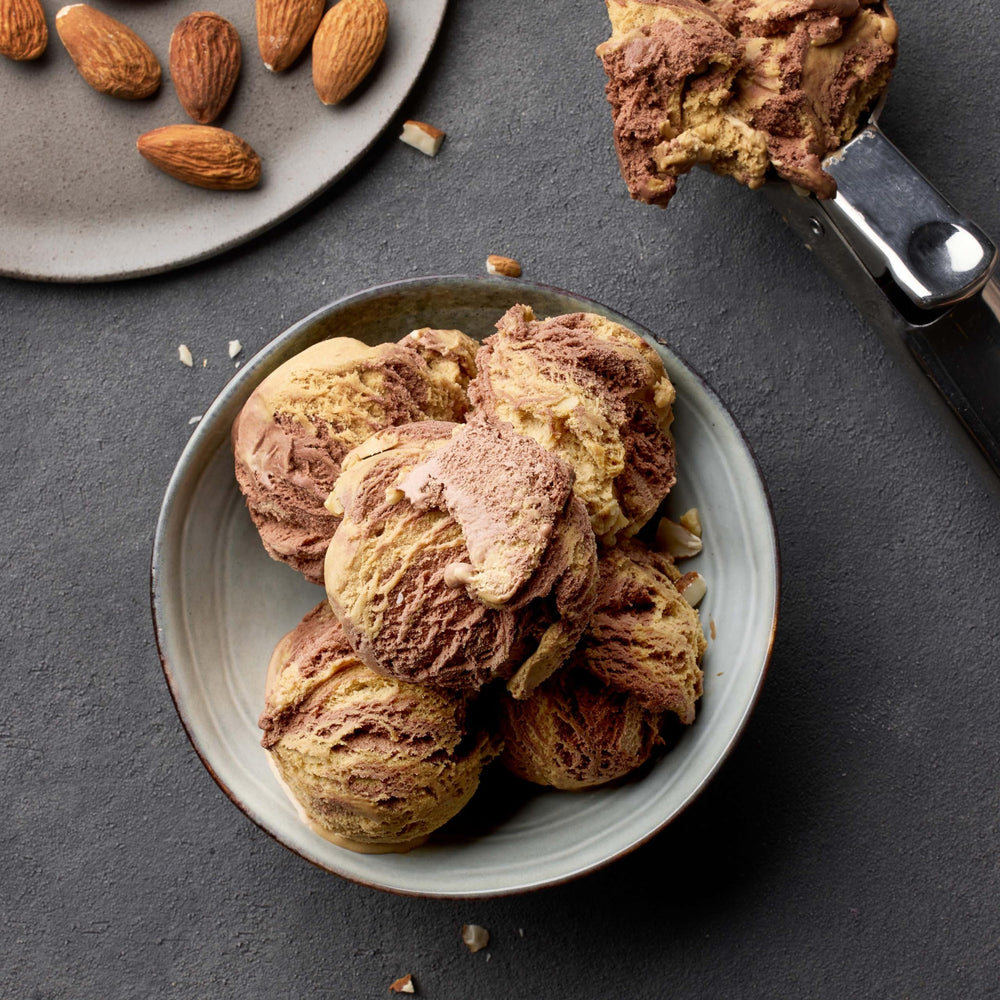 Almonds pouring from bag to measure cup for portion control