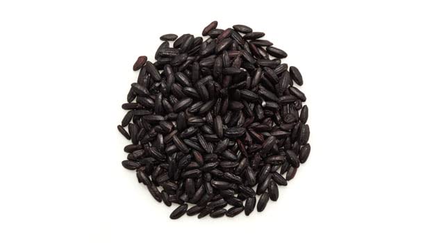 Raw dark grains of Yupik black rice before simmering in a pot.
