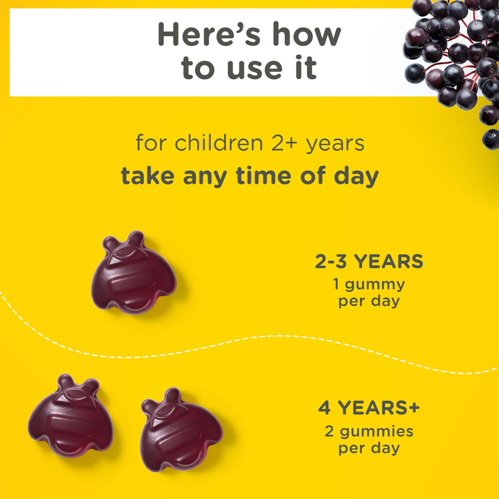 Parent helps a child take Zarbee's elderberry gummies.