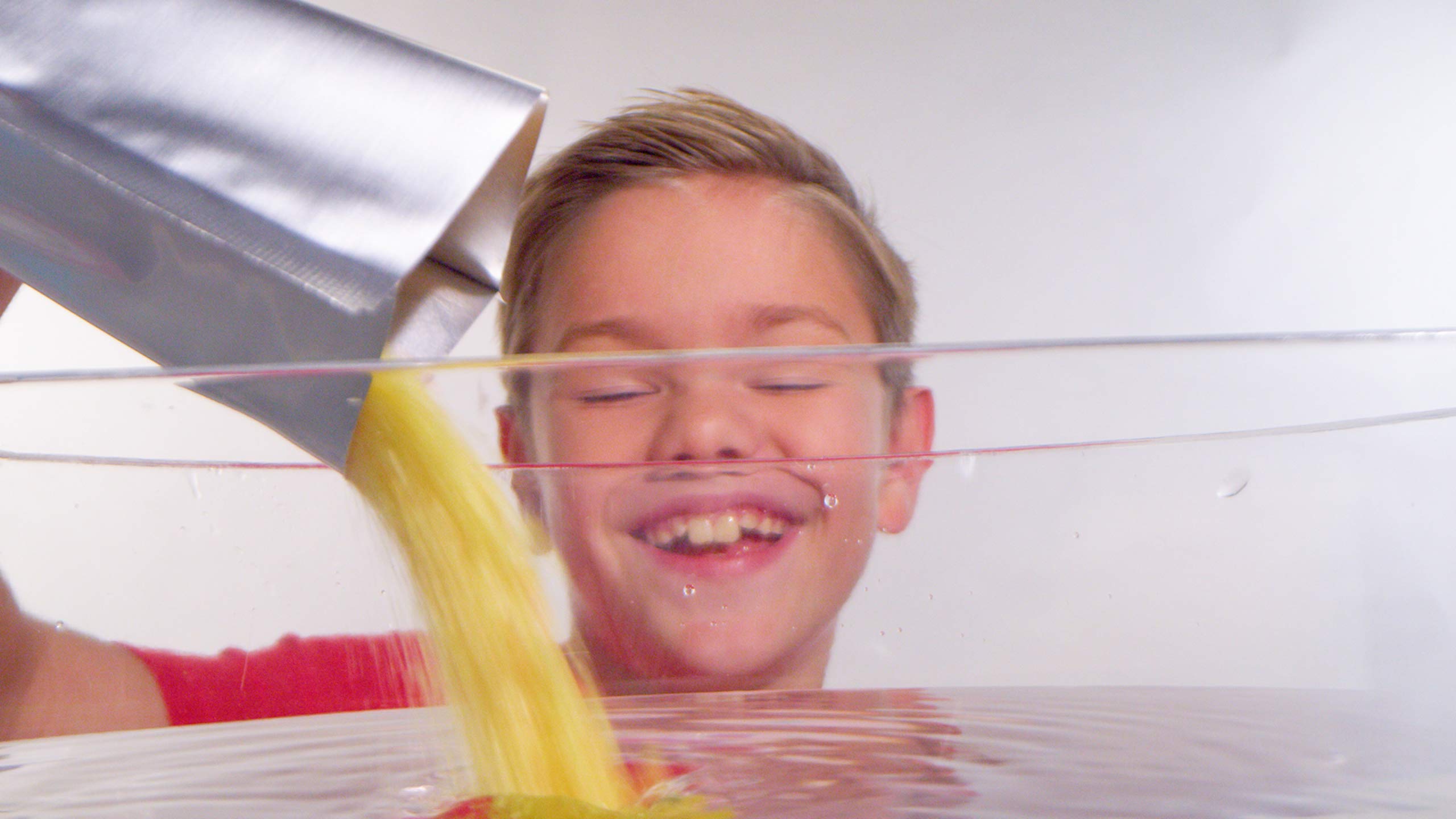 Zimpli Kids Crackle Baff Colours pour demonstrates powder sprinkling for crackling bath magic.
